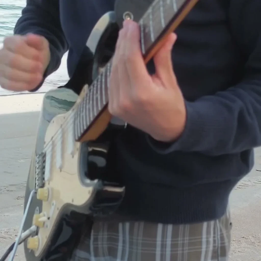 Stolen Dance Guitar Loop guitarist at the beach playing one guitar session